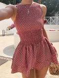 Woman wearing the Modarine gingham smocked drop-waist mini dress