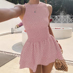 Woman wearing the Modarine gingham smocked drop-waist mini dress