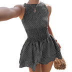 Woman wearing the Modarine gingham smocked drop-waist mini dress