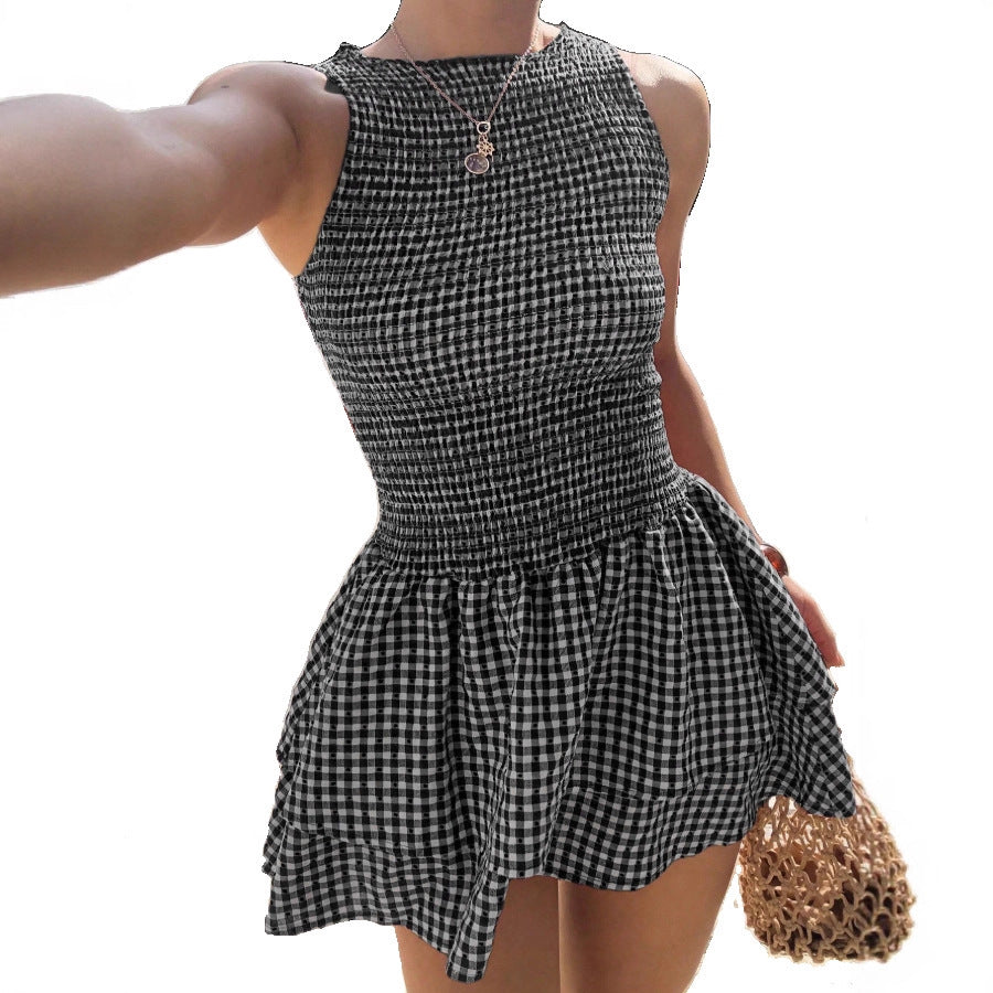 Woman wearing the Modarine gingham smocked drop-waist mini dress