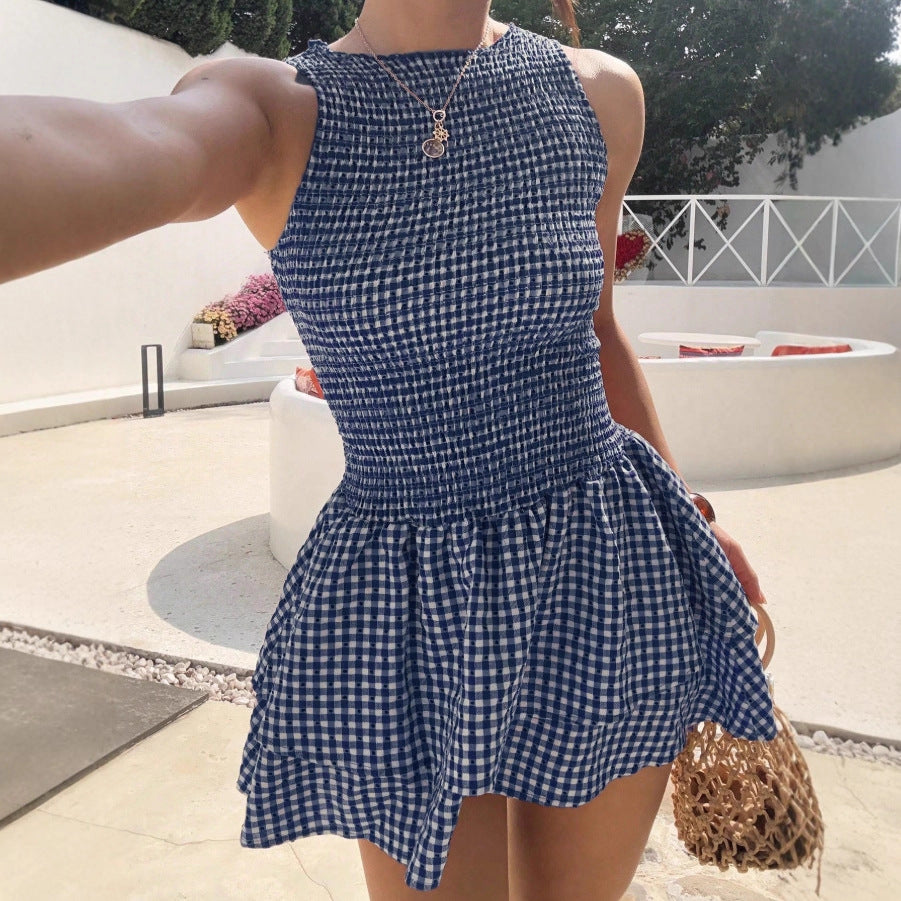 Woman wearing the Modarine gingham smocked drop-waist mini dress