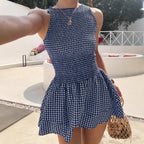 Woman wearing the Modarine gingham smocked drop-waist mini dress